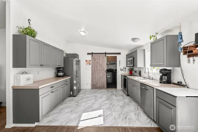 a large kitchen with stainless steel appliances kitchen island a sink stove and refrigerator