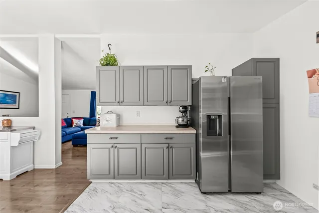 a kitchen with a refrigerator sink and cabinets