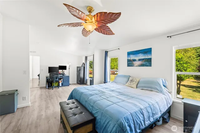 a bedroom with a bed a dresser next to a window