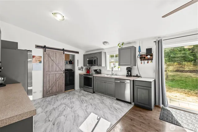 a kitchen with stainless steel appliances granite countertop a refrigerator and a sink