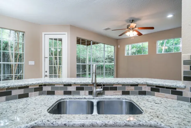 a kitchen with a sink a counter top space and living room area