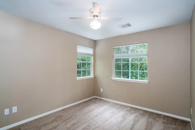 an empty room with a window and a fan