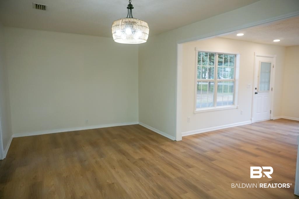 4734 Kirkwell Drive Mobile, AL 36619 - Photo 12 of 18 Unfurnished room with hardwood / wood-style flooring and a notable chandelier