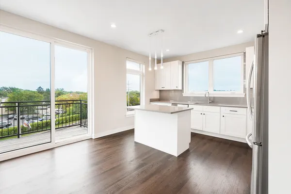 a kitchen with a large window appliances and cabinets
