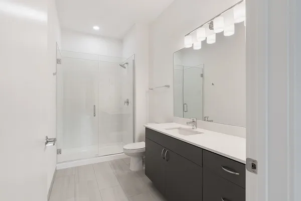 a bathroom with a sink a toilet and shower