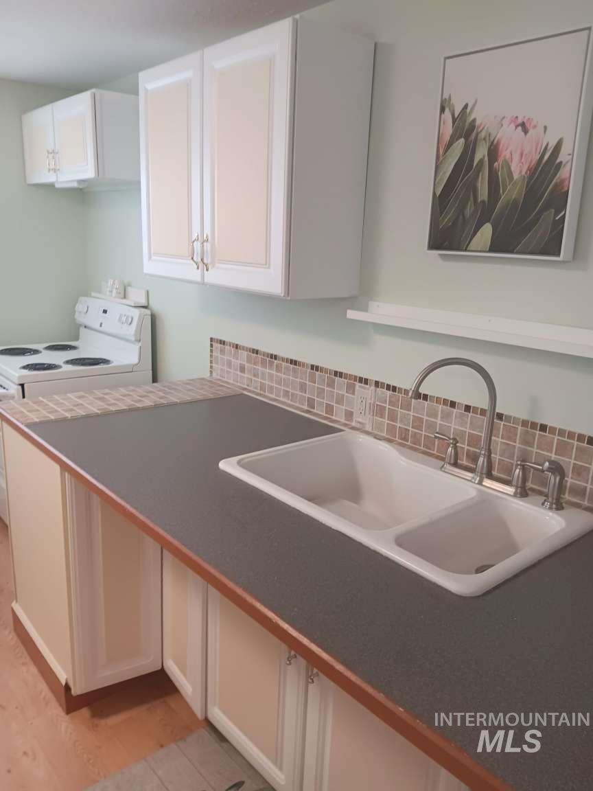 269 South State Street Hagerman, ID 83332 - Photo 13 of 29 Kitchen with white cabinetry, white electric range oven, and dark countertops