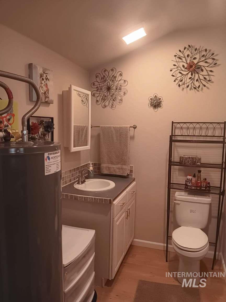 269 South State Street Hagerman, ID 83332 - Photo 19 of 29 Half bath with vanity, water heater, and light wood-style flooring