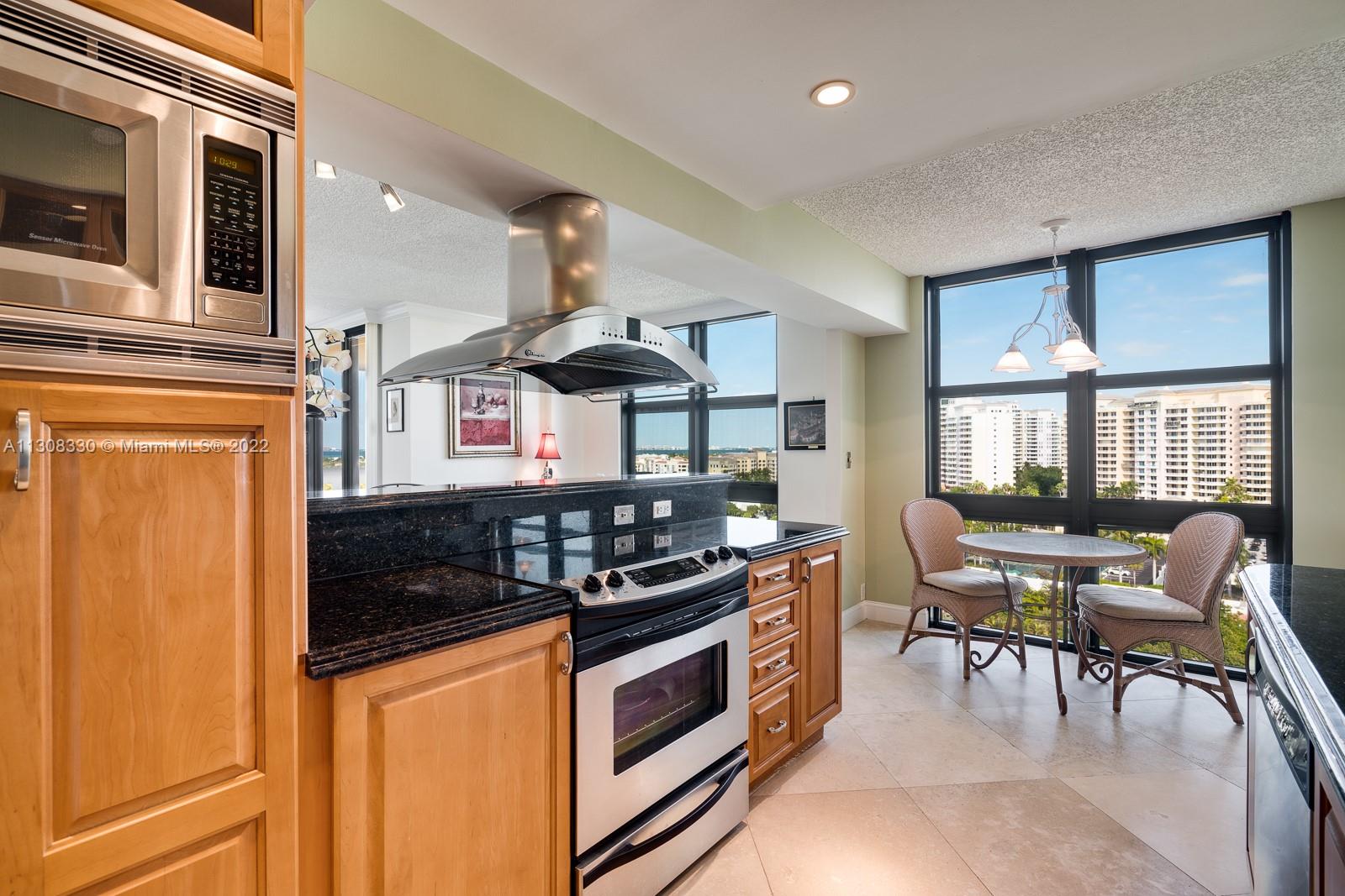 1121 Crandon Boulevard, Unit E1101 Key Biscayne, FL 33149 - Photo 11 of 31 a kitchen with stainless steel appliances granite countertop a stove a sink and a refrigerator