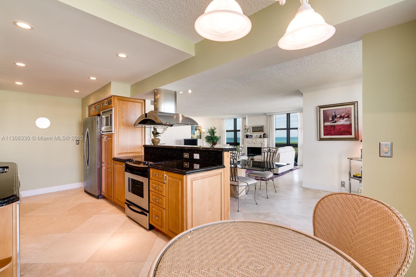 1121 Crandon Boulevard, Unit E1101 Key Biscayne, FL 33149 - Photo 13 of 31 a kitchen with stainless steel appliances kitchen island granite countertop a sink and a refrigerator