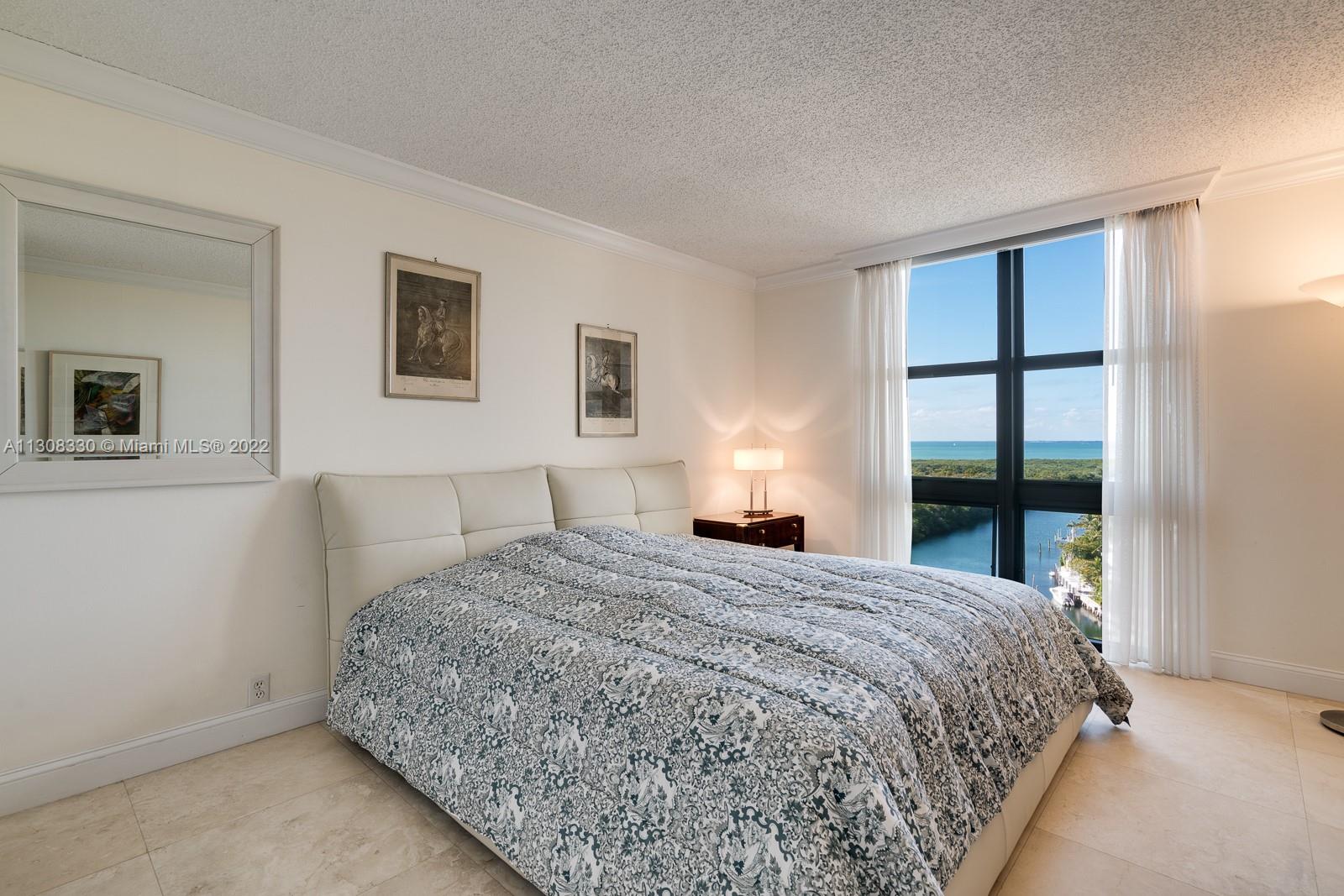1121 Crandon Boulevard, Unit E1101 Key Biscayne, FL 33149 - Photo 16 of 31 a bedroom with a large bed and a window