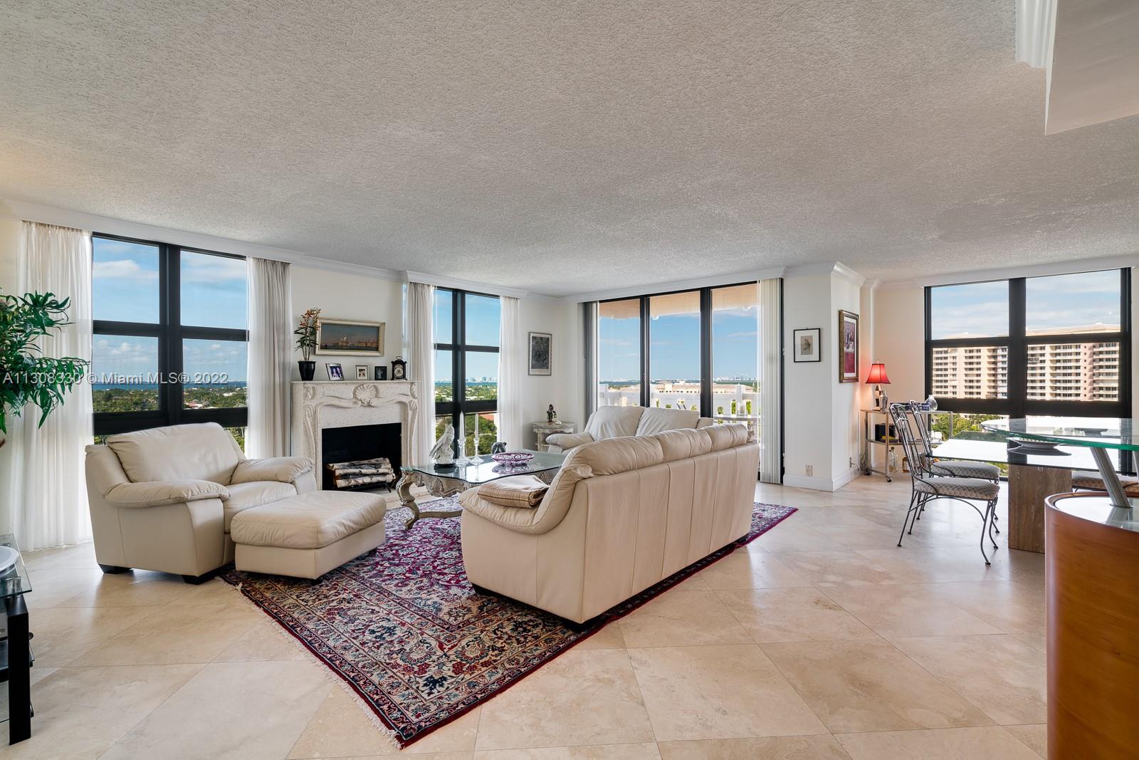 1121 Crandon Boulevard, Unit E1101 Key Biscayne, FL 33149 - Photo 7 of 31 a living room with furniture a fireplace a flat screen tv and a large window