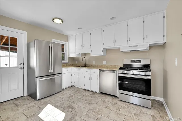a kitchen with stainless steel appliances granite countertop a refrigerator sink and stove