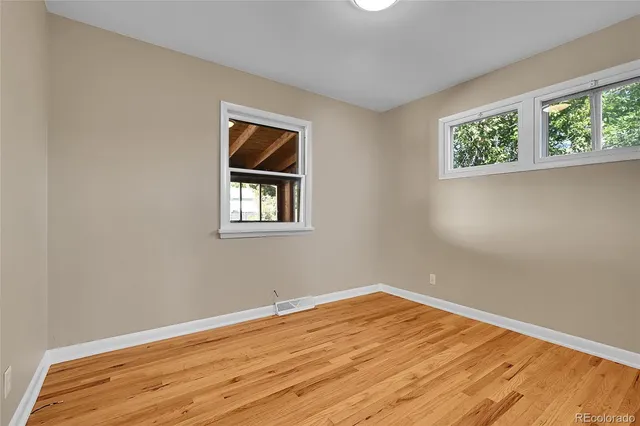 a view of a room with wooden floor and window