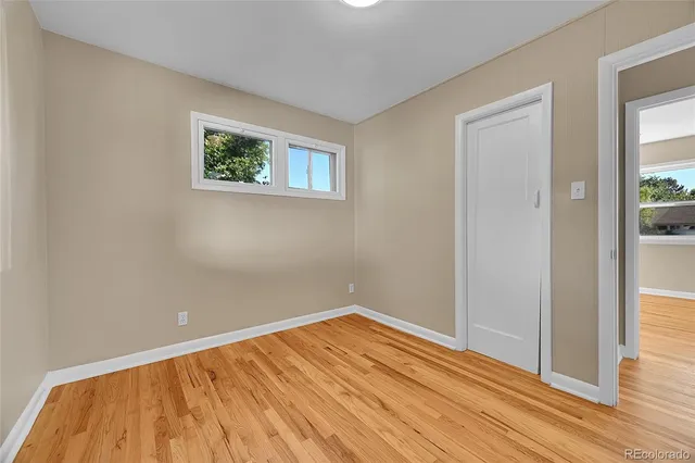 a view of empty room with wooden floor