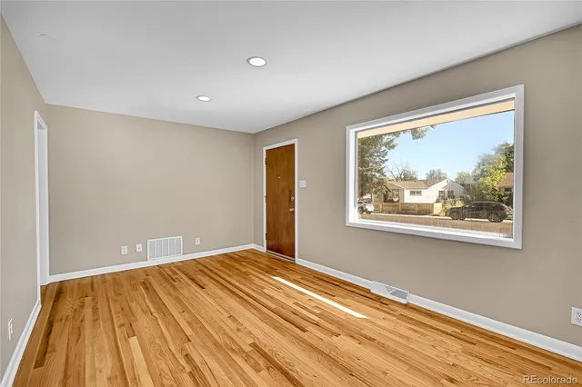 a view of empty room with wooden floor