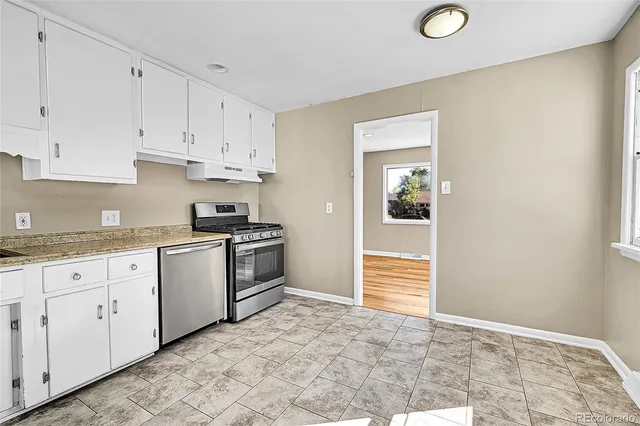 a kitchen with granite countertop white cabinets and white appliances