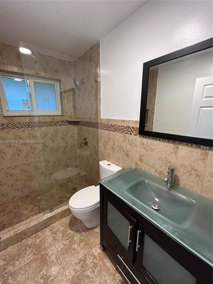 230 Southwest 30th Avenue, Unit 230 Miami, FL 33135 - Photo 17 of 22 a bathroom with a sink a toilet and mirror