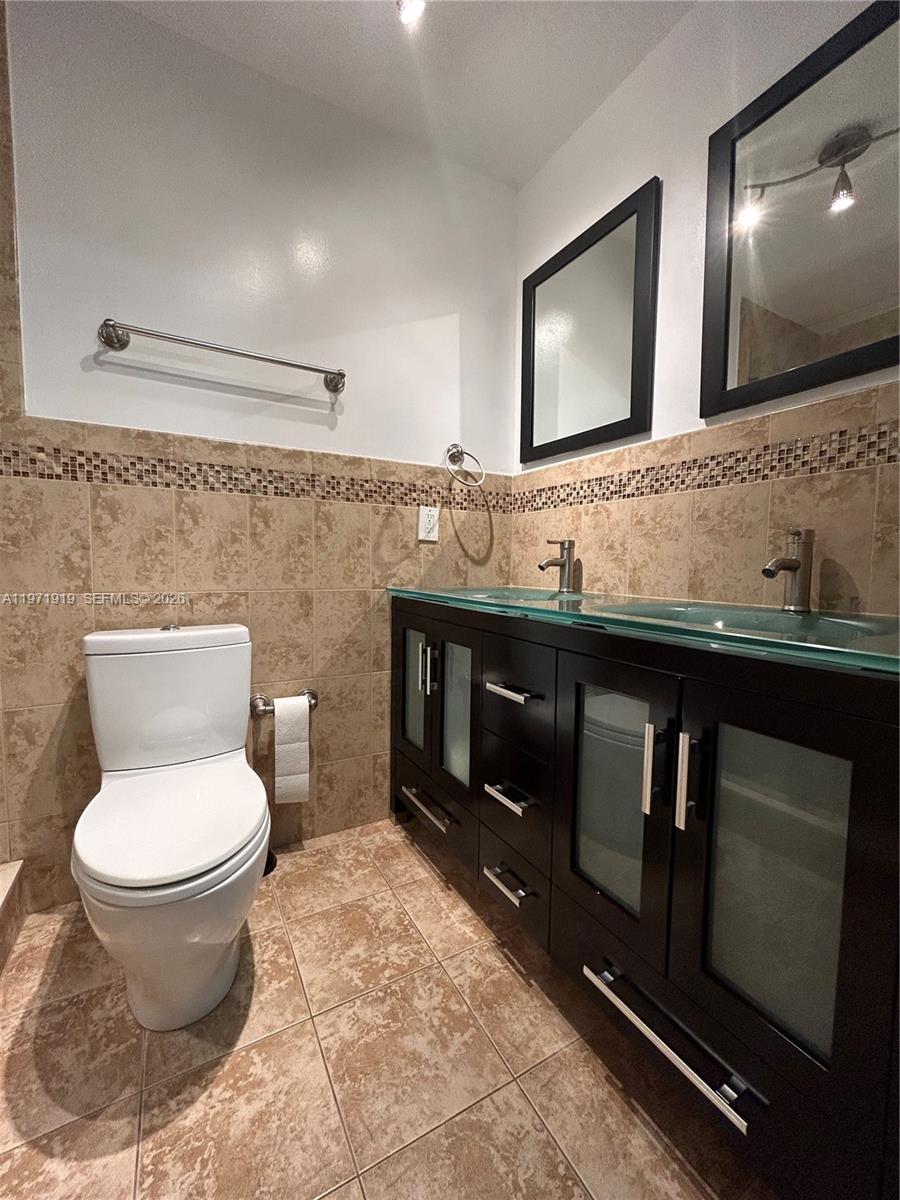 230 Southwest 30th Avenue, Unit 230 Miami, FL 33135 - Photo 8 of 22 a bathroom with a toilet sink and mirror