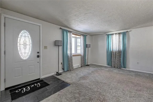 an empty room with mirror and windows