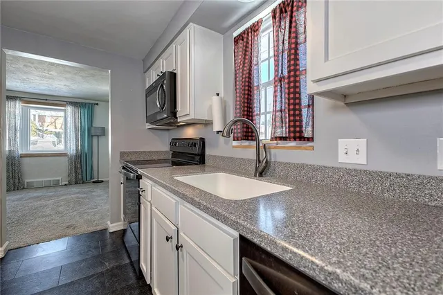 a kitchen with a sink dishwasher a stove and a refrigerator with wooden floor
