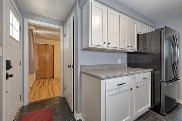 a kitchen with white cabinets and a refrigerator