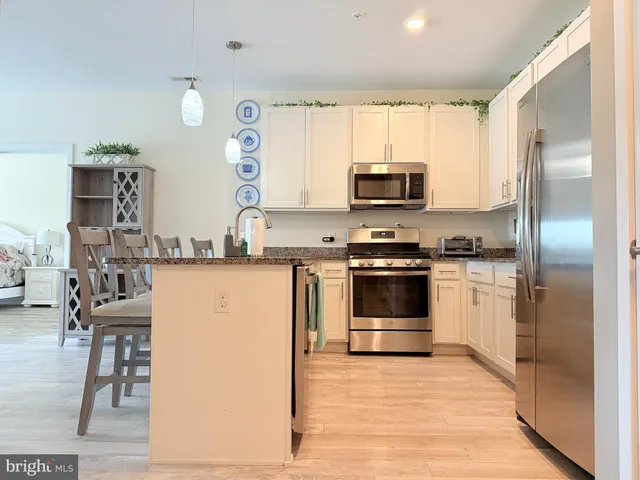 a kitchen with granite countertop a refrigerator stove top oven and sink