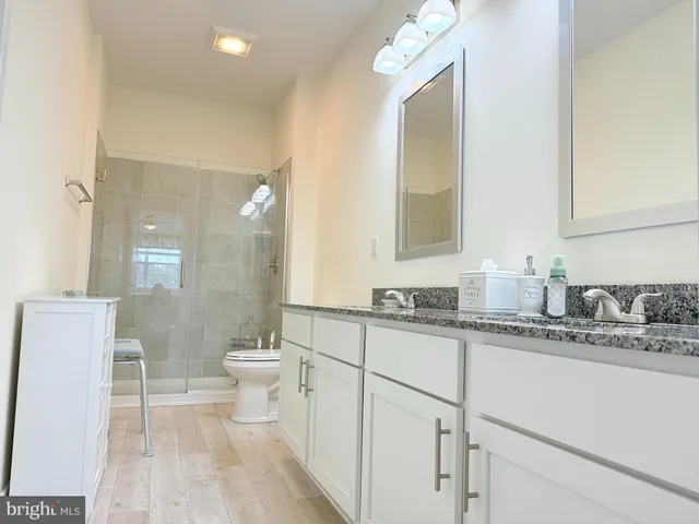 a bathroom with a sink a toilet and a mirror