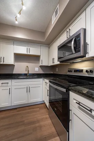 a kitchen with stainless steel appliances granite countertop a stove microwave and oven