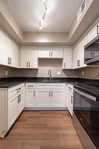 a kitchen with granite countertop a sink and cabinets