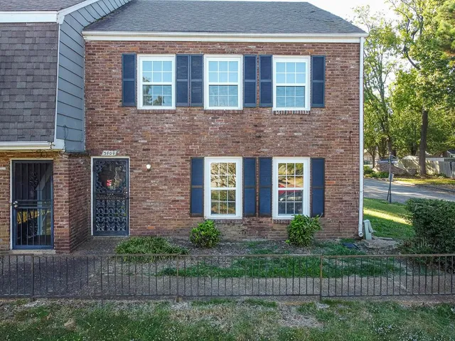 a front view of brick house with a yard