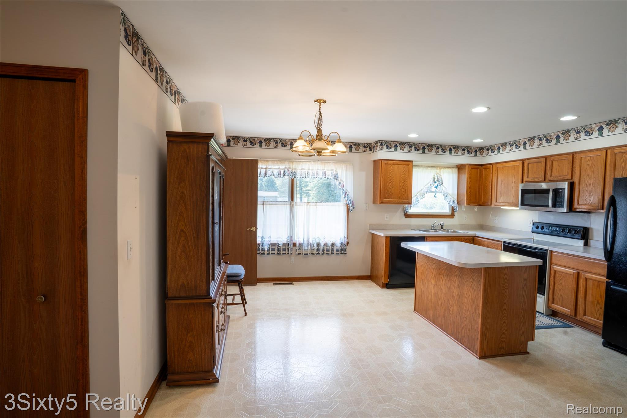 1783 Farnsworth Road Lapeer, MI 48446 - Photo 17 of 51 Kitchen featuring black appliances, light flooring, a kitchen island, light countertops, and a chandelier