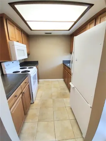 a kitchen with a stove top oven cabinets and a refrigerator