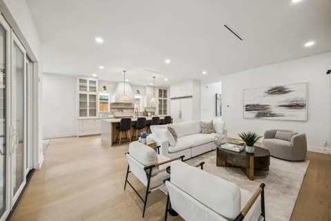a living room with furniture and a dining table with kitchen view