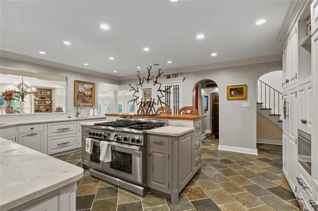 a kitchen with stainless steel appliances granite countertop a stove a sink and a refrigerator