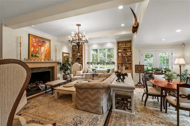 a living room with furniture a fireplace and a chandelier