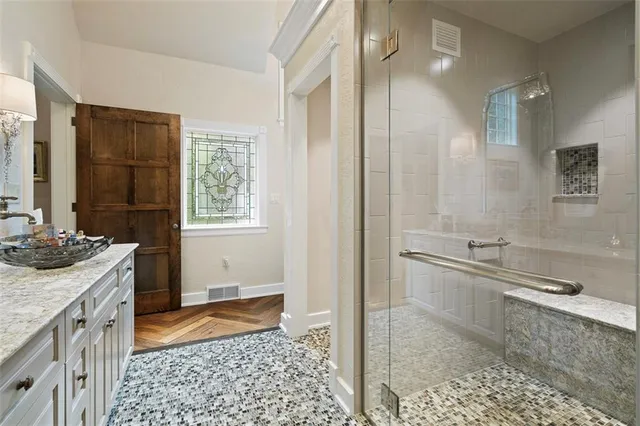 a bathroom with a granite countertop sink a mirror and a bathtub