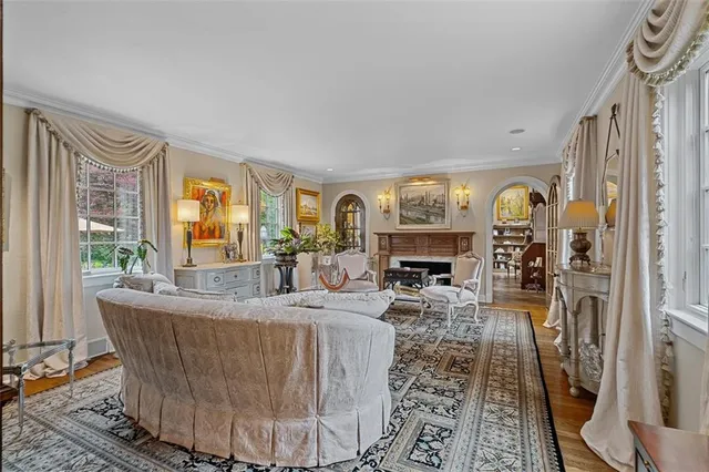 a living room with fireplace furniture and a large window