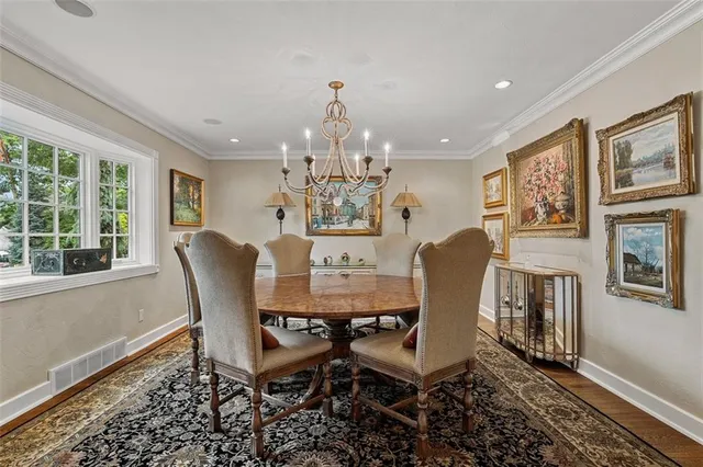 a view of a dining room with furniture a chandelier and wooden floor