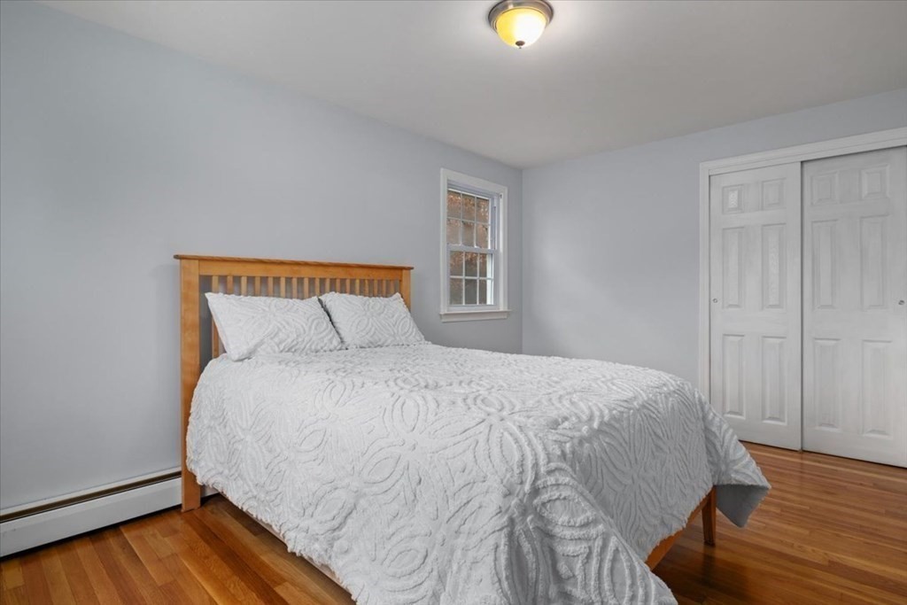124 Turtle Pond Parkway Boston, MA 02136 - Photo 20 of 39 a bed sitting in a bedroom next to a window