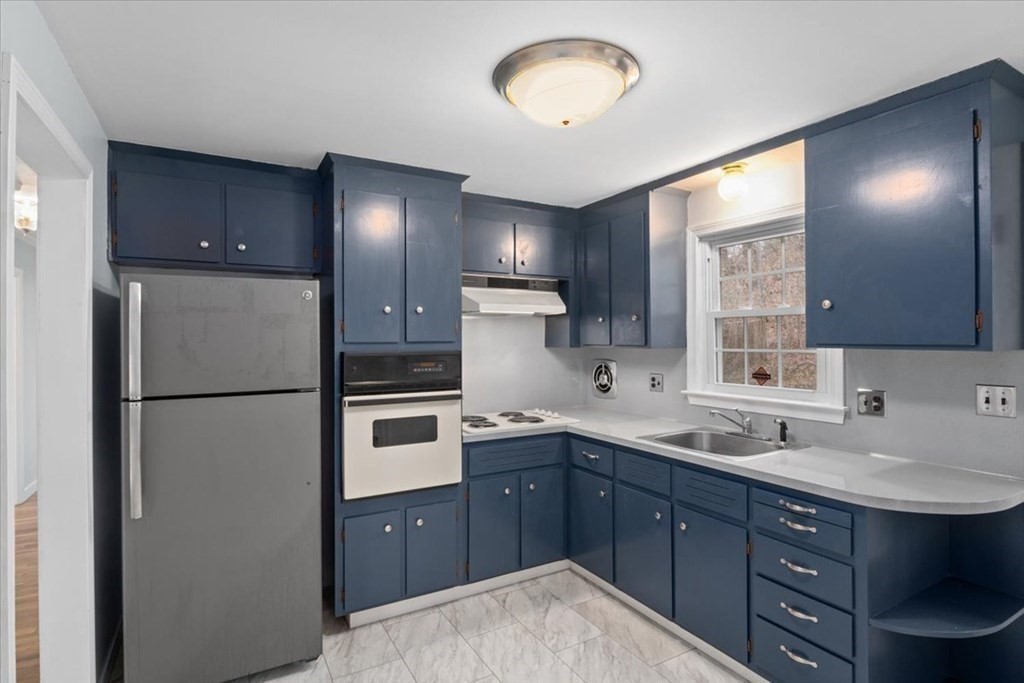 124 Turtle Pond Parkway Boston, MA 02136 - Photo 5 of 39 a kitchen with a sink a refrigerator and cabinets