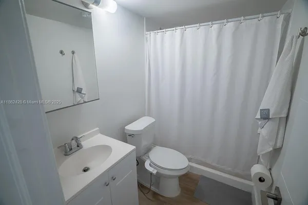 a bathroom with a toilet sink vanity and mirror