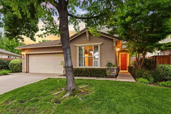 a front view of a house with a yard and trees