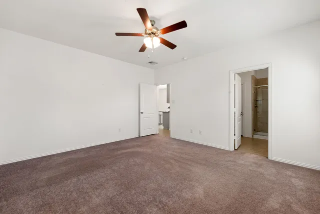 an empty room with closet and ceiling fan
