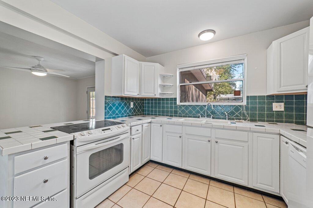 6147 Temple Road Jacksonville, FL 32217 - Photo 12 of 36 a kitchen with granite countertop white cabinets stainless steel appliances a sink and a window