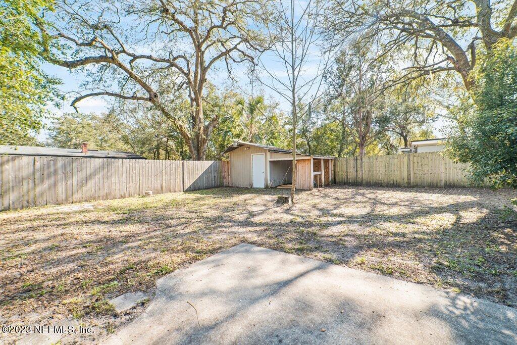 6147 Temple Road Jacksonville, FL 32217 - Photo 32 of 36 a backyard of a house with large trees and wooden fence