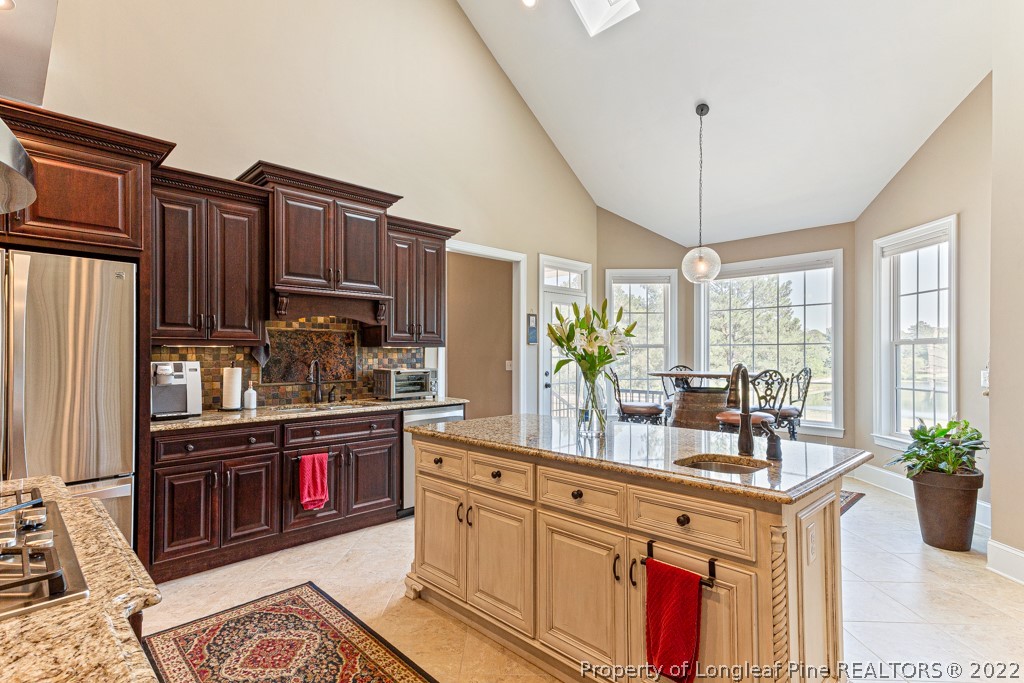 375 East Lake Ridge Road Raeford, NC 28376 - Photo 19 of 50 a kitchen with stainless steel appliances granite countertop a refrigerator a stove a sink dishwasher and wooden cabinets with wooden floor