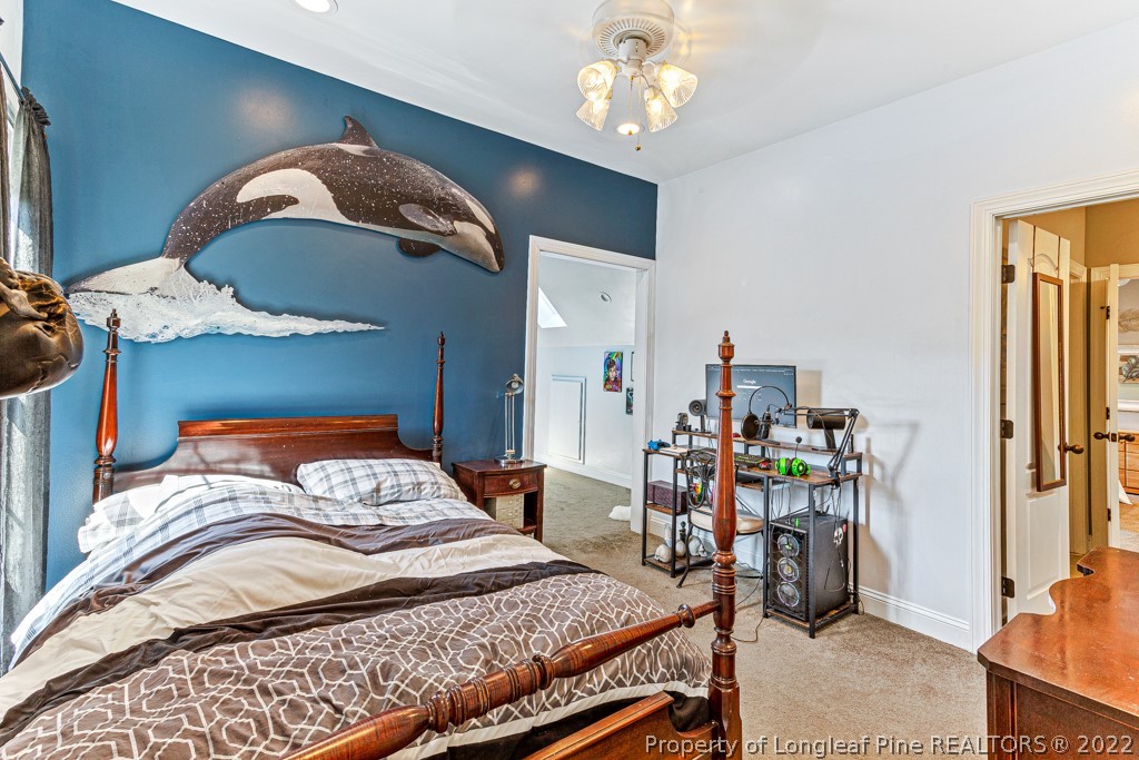 375 East Lake Ridge Road Raeford, NC 28376 - Photo 34 of 50 a bedroom with a bed and a chandelier