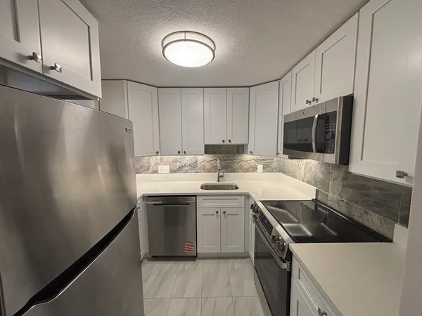 a kitchen with stainless steel appliances a stove microwave and sink