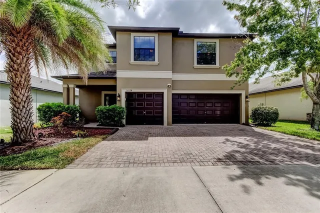 a front view of a house with a yard and a garage