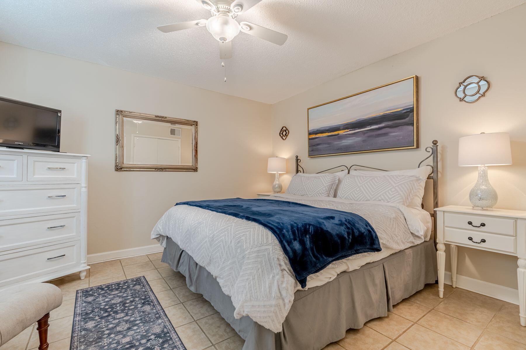 56 Sunset Bay, Unit 17B Miramar Beach, FL 32550 - Photo 13 of 30 a bedroom with a bed and a tv on the dresser